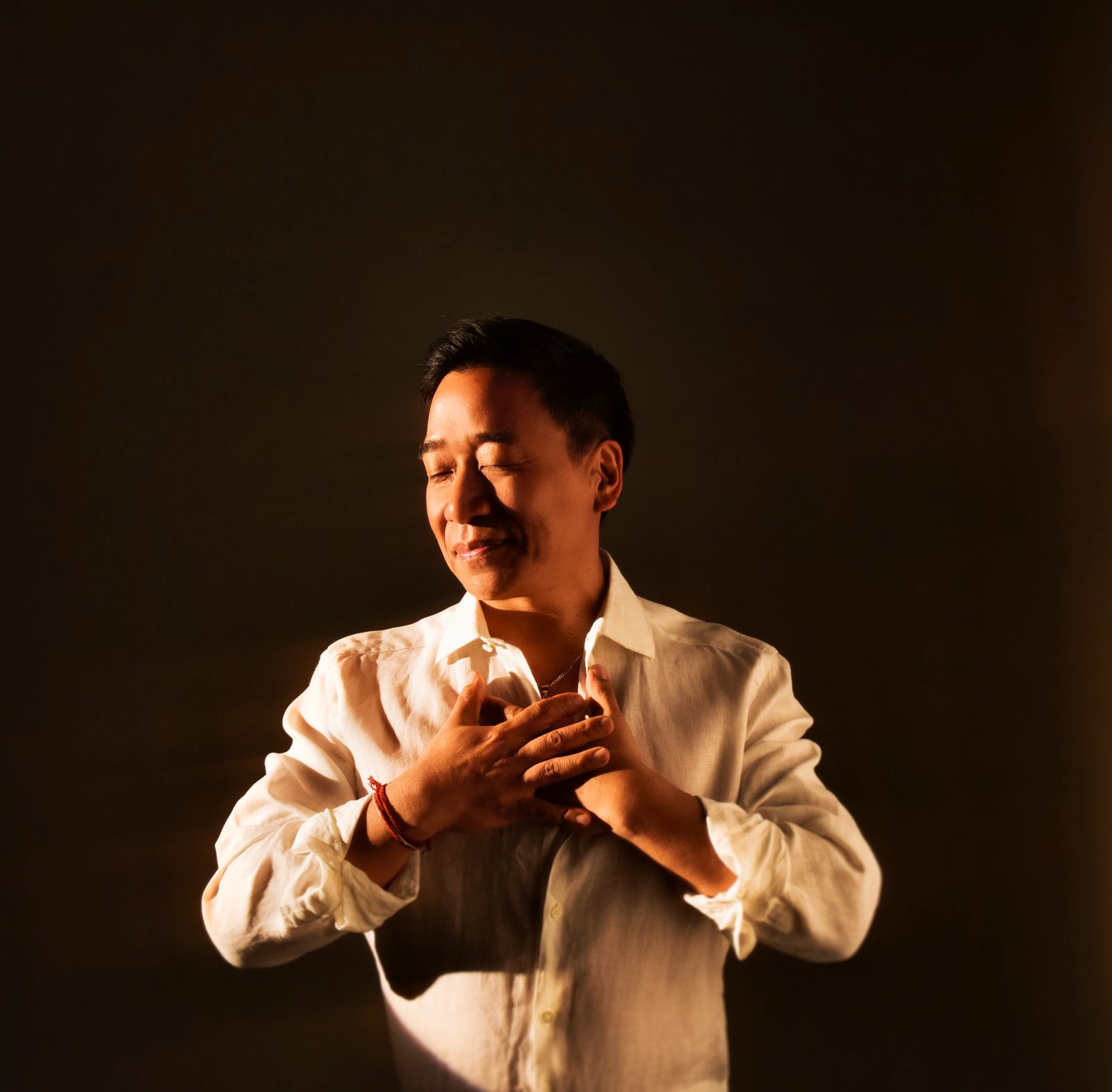 Ian Pai smiling with his hands over his heart